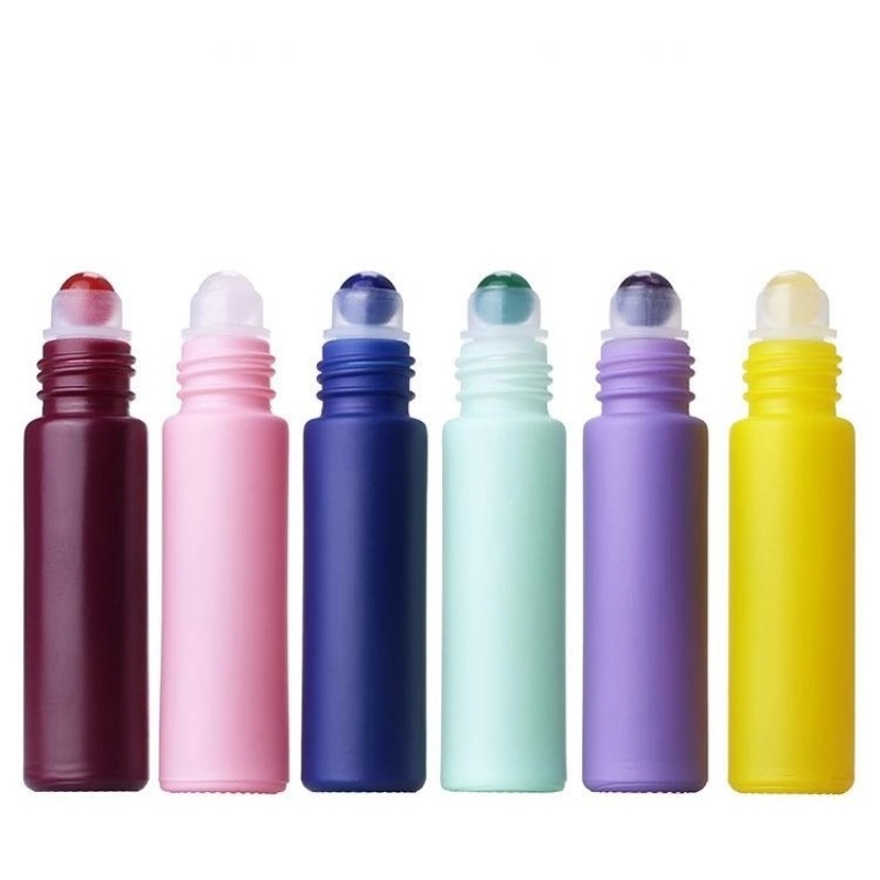 Factory wholesale colored perfume and essential oil glass bottles in various styles, including frosted rollerball bottles.