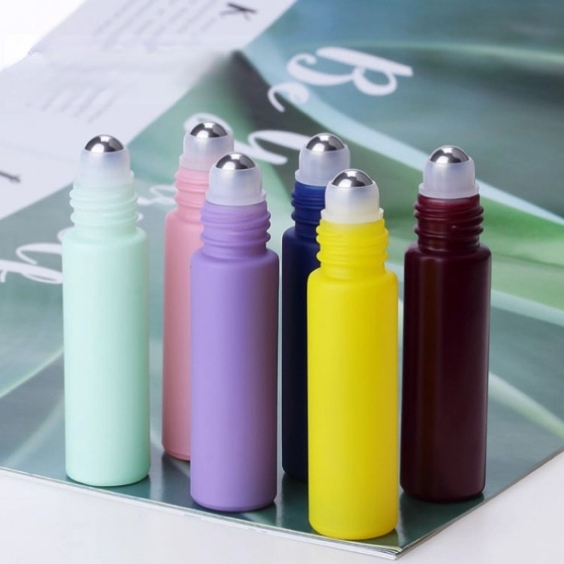 Factory wholesale colored perfume and essential oil glass bottles in various styles, including frosted rollerball bottles.